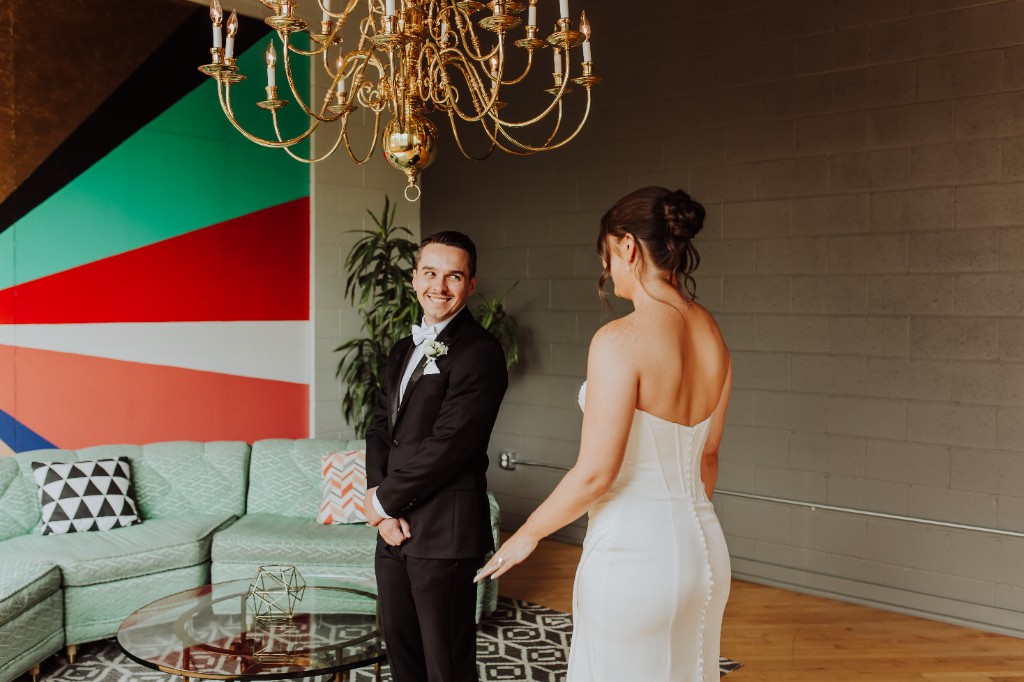 Jack Mahoney in a tuxedo with his partner in a modern creative space